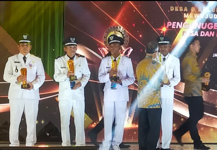 Menteri Dalam Negeri , Tito Karnavian Menyerahkan Piala Juara 3 Kepada Kepala Kampung, Sudirman. ( Sumber Gambar : Agus) 
