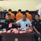 KBO Sat Narkoba Ipda Hery didampingi Kasi Humas Ipda Teguh dan Penyidik Pembantu Bripka Kasmin Musa tampak depan bersama barang bukti , dan tampak dibelakang tiga tersangka mengenakan baju berwarna kuning.
