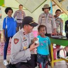 Kapolsek Babo, Ipda Stenlis Ayub Marani foto bersama seorang anak saat memberikan bantuan Bapokting di Distrik Fafurwar.  Jum'at (15/9) /foto: istimewa. 