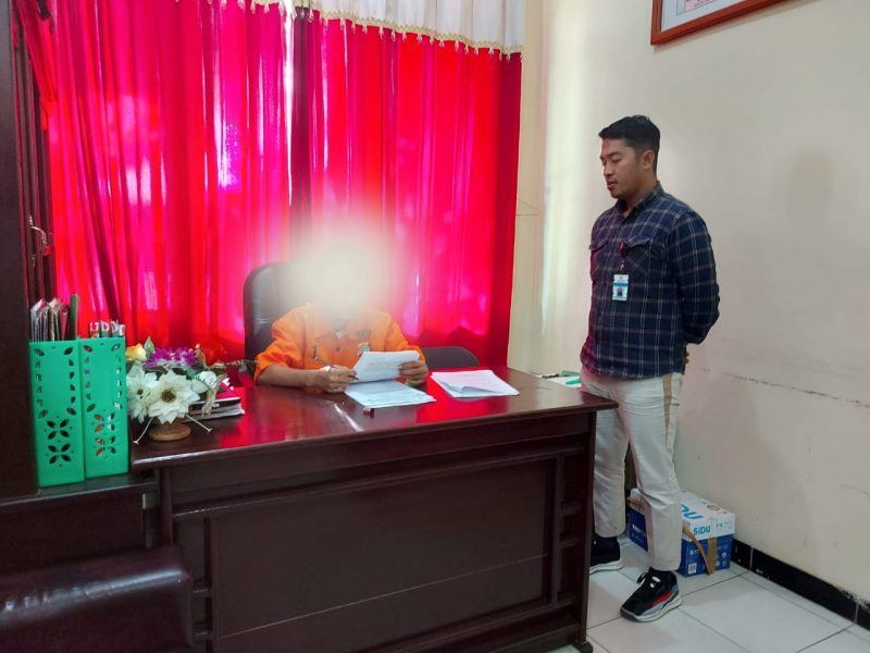 Salah satu tahanan narkoba berinisial JO (di blur) mengikuti ujian tengah semester di ruangan penyidik Polres Teluk Bintuni. Selasa (10-10-2023) sore.