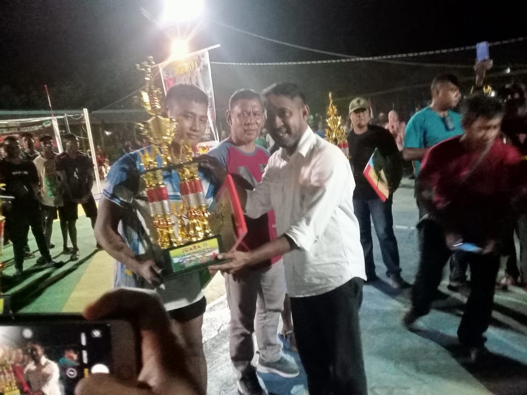 Ketua PBVSI Teluk Bintuni Yohanis Manibuy menyerahkan piala kepada pemenang pertandingan Turnamen Bola Volley Dandim Cup I, Senin (23/10) 