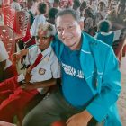 Ketua KNPI Teluk Bintuni, Kenny R. Kindewara foto bersama seorang pelajar Sekolah Dasar (SD). 