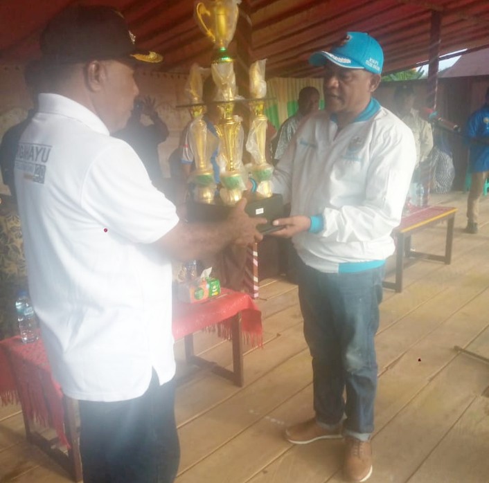 Ketua DPD KNPI Teluk Bintuni menyerahkan piala utama kepada Kepala Distrik Babo pada pembukaan pertandingan Bola Voli dan Futsal di Babo.