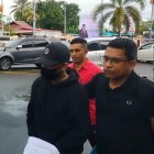 RFYR(menggunakan topi hitam, jaket hitam, dan masker) dengan tangan diborgol dan dikawal tim Tabur Kejati Papua Barat, saat tiba di Bandara  Rendani, Rabu(1/11) 