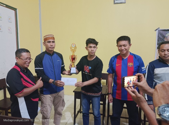 Keterangan Gambar ; Ketua KKSS Kabupaten Teluk Bintuni menyerahkan Tropy dan uang pembinaan kepada Erdison Simangunsong, Minggu (12/11/203) /foto : Haiser 