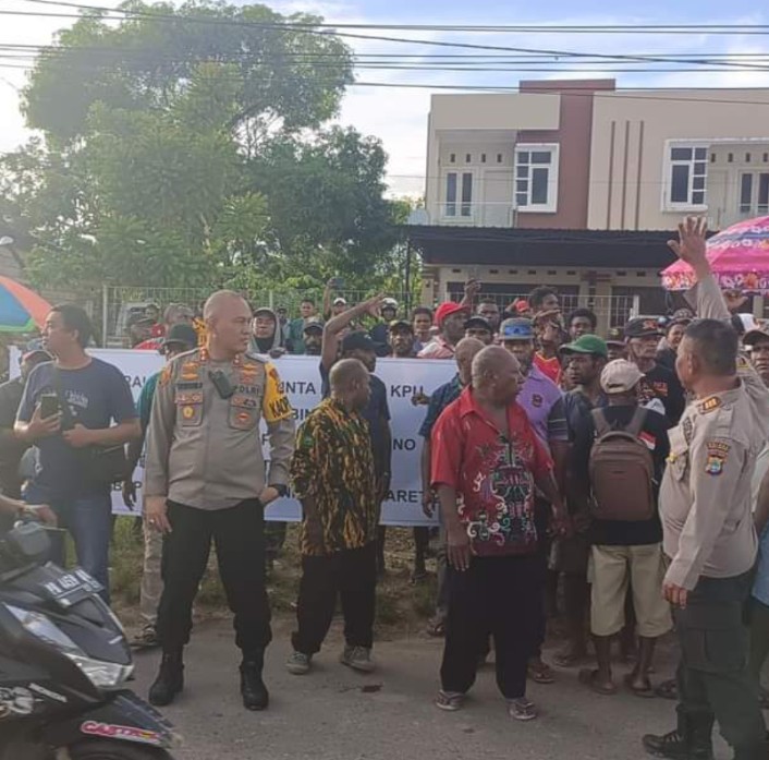 Tampak Kapolres Teluk Bintuni, AKBP Chairuddin Wachid berada di kerumunan massa saat masyarakat sebyar meminta kepada KPU Kabupaten Teluk Bintuni untuk segera menetapkan hasil pleno rekapitulasi perhitungan suara tingkat kabupaten pada hari ini Rabu, 06 Maret 2024.