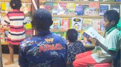 Anak-anak sedang membaca buku di perpustakaan apung Tantya Sudhitarajati, diawasi oleh personil Satpolairud Polres Teluk Bintuni, salah satu program inovatif pada Kamis (18/04/2024).