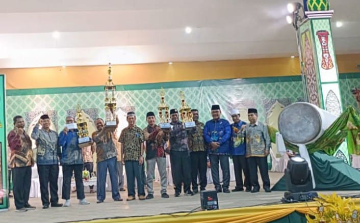 Kafilah Distrik Bintuni Pertahankan Gelar Juara Umum di MTQ Ke-X Kabupaten Teluk Bintuni, 
Selasa malam (21/05/2024), tampak kepala Distrik Bintuni, Moses Koropasi, mengangkat piala bergilir saat acara penutupan di Panggung Gelanggang Argosigemarai, Bintuni Timur.
