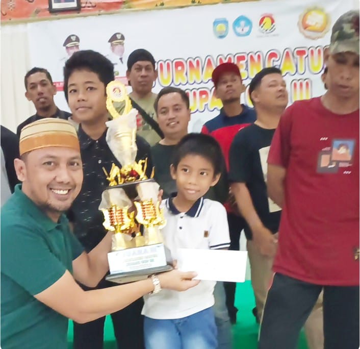 Ketua Harian PERCASI Teluk Bintuni, Yasman Yasir, menyerahkan trofi dan uang pembinaan kepada peserta kategori pelajar pada turnamen catur Bupati Teluk Bintuni Cup III pada Jumat (5/7) malam.