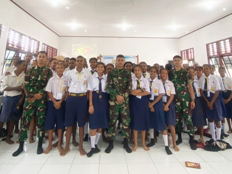 Prajurit Yonif 763/SBA berfoto bersama siswa-siswi setelah melaksanakan kegiatan Masa Pengenalan Lingkungan Sekolah (MPLS) di SMAS YPPK ST ARNOLDUS YANSEN, Distrik Wesiri, pada Rabu (17/7/2024).