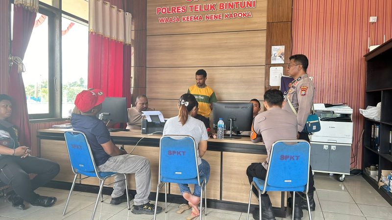 Tampak dari belakang, Ibu Herlina (rambut terikat) didampingi oleh Yohanes Akwan (topi merah) ketika melaporkan BRI Cabang Bintuni ke Polres Teluk Bintuni pada Jumat, 2 Agustus. Foto: istimewa.
