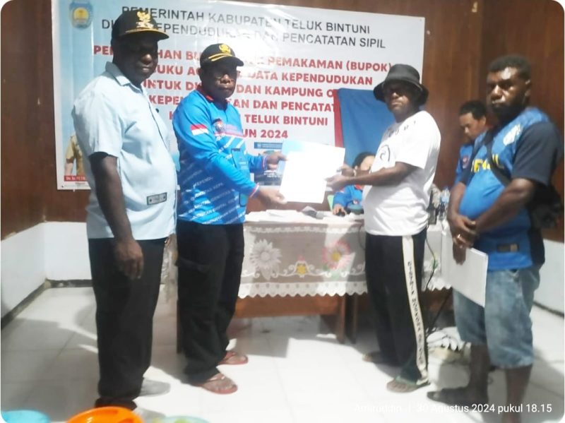Dukcapil Teluk Bintuni Melayani Hingga Ke Kampung-Kampung Fredrik Paduai: Dibutuhkan Pemimpin Yang Siap Melayani  Plt. Dukcapil ( mengenakan baju berlengan panjang) menyerahkan Buku Pokok Pemakaman (Bupok) dan Buku Agregat Data Kependudukan untuk distrik dan kampung di Kabupaten Teluk Bintuni tahun 2024. (Dokumentasi: Amiruddin)