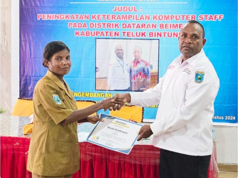 Sekretaris Distrik Dataran Beimes, Yance Anire, SE., MM (berkemeja putih), menyerahkan sertifikat sebagai bukti partisipasi kepada salah satu peserta.