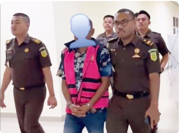 Tersangka JK, mengenakan rompi pink , dikawal oleh jaksa menuju mobil tahanan Kejaksaan Negeri Teluk Bintuni pada Kamis malam (5/9).