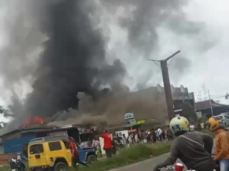 Asap hitam tebal mengepul dari dua toko yang terbakar di Bintuni.  