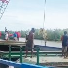 Keterangan Gamau: Dalam sebuah video yang beredar luas, terlihat seekor buaya besar diangkut menggunakan alat berat berupa crane di area pelabuhan. Sumber: Facebook, Selasa (28/1), berdasarkan tangkapan layar.  