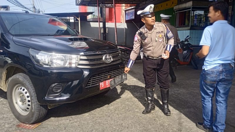Anggota Satlantas Polresta Manokwari, Bripka Aku saat memberhentikan Kendaraan Mobil dinas yang berplat ganda. Jumat(14/2/25) di jalan H.Bouw,Wosi Manokwari