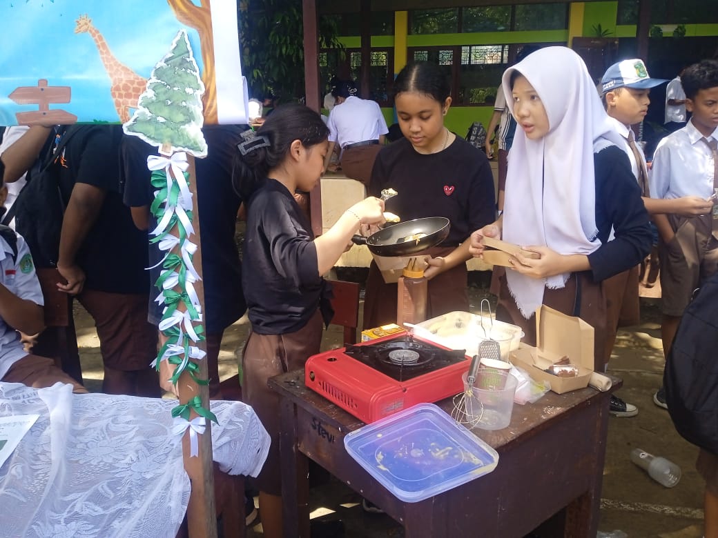 Siswi Kelas 9 yang mencoba untuk membuat kue dari pesanan pembeli saat acara pameran,Rabu[26/2/25)