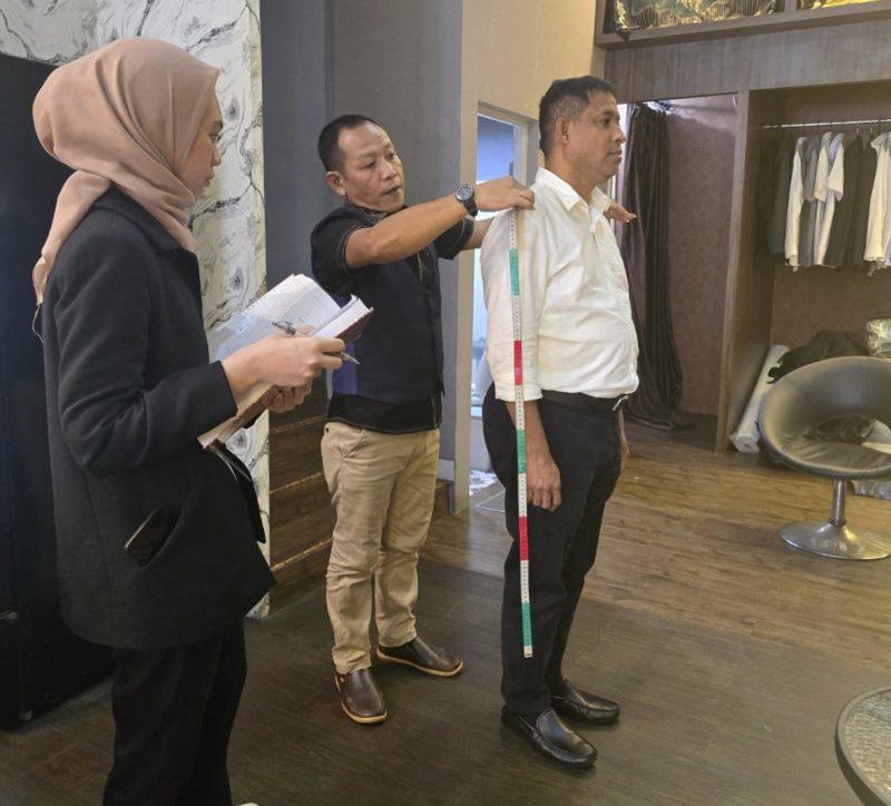 Bupati Teluk Bintuni, Yohanis Manibuy, melakukan pengukuran pakaian untuk pelantikan.  