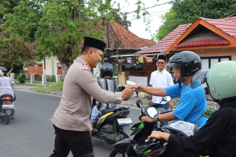 Kapolres Sumbawa, AKBP Bagus Nyoman Gede Junaedi, S.H., S.I.K., M.AP., membagikan takjil di Jalan Hasanuddin, Sumbawa, sambil menyapa warga.  