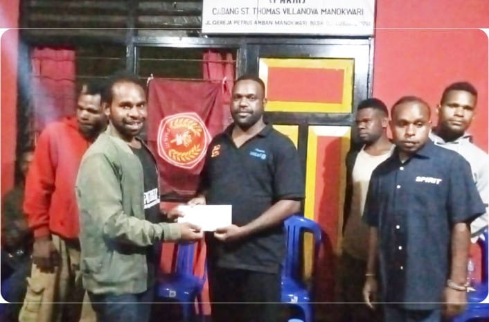 Lamek Dowansia, A.Md.Par (kaos hitam), menyerahkan bantuan kepada Sekretariat Perhimpunan Mahasiswa Katolik Republik Indonesia (PMKRI) Cabang Manokwari Sanctus Thomas Villanova pada 16 Maret 2025.
