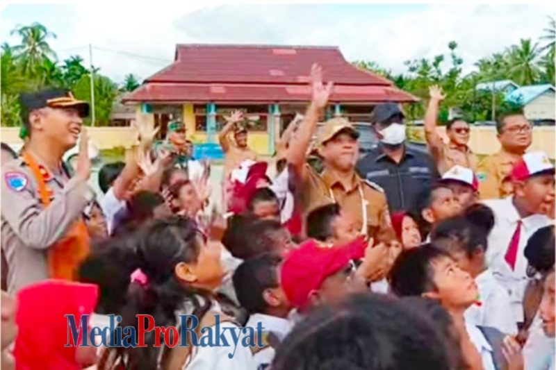 Bupati Teluk Bintuni tampak bergembira bersama para siswa sekolah dasar saat meluncurkan Program Makan Bergizi Gratis.  