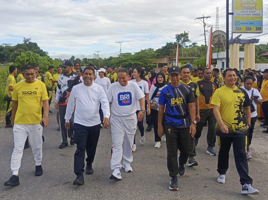 Tampak Bupati Teluk Bintuni mengenakan kaos putih lengan panjang dan celana hitam saat mengikuti jalan santai dalam rangka peringatan HUT Bhayangkara ke-79, Sabtu (28 Juni 2025).