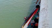 Sebuah perahu milik warga Babo terbalik saat hendak melakukan bongkar muat dari KM Fajar Mulia yang sedang labuh jangkar di perairan Babo, Minggu (3/8). Foto: Kiriman warga Babo.