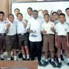 Keterangan Gambar: Marten berfoto bersama siswa-siswi SMP Negeri 2 Manokwari usai berbagi ilmu menulis.
