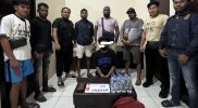 Dalam gambar: Pimpinan Sat Narkoba Polres Teluk Bintuni bersama anggotanya saat mengamankan seorang pria mengenakan masker hitam yang kedapatan memiliki paket ganja siap edar beserta barang bukti lainnya. Foto diambil setelah pelaku diamankan di Markas Polres Teluk Bintuni, Selasa (28/10/2025). Sumber foto: Humas Polres Teluk Bintuni.