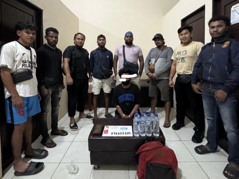 Dalam gambar: Pimpinan Sat Narkoba Polres Teluk Bintuni bersama anggotanya saat mengamankan seorang pria mengenakan masker hitam yang kedapatan memiliki paket ganja siap edar beserta barang bukti lainnya. Foto diambil setelah pelaku diamankan di Markas Polres Teluk Bintuni, Selasa (28/10/2025). Sumber foto: Humas Polres Teluk Bintuni.