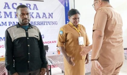 Keterangan gambar: Kepala Dinas Pendidikan, Kebudayaan, Pemuda dan Olahraga Kabupaten Teluk Bintuni, Dr. Henry D. Kapuangan, berjabat tangan dengan peserta usai menyematkan tanda peserta pada kegiatan Program Cakap Membaca dan Berhitung (GASING) Fase II di SMP Negeri 2 Bintuni, Senin (3/11/2025).