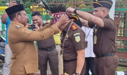 Tampak Wakil Bupati Teluk Bintuni menyematkan mahkota dan noken adat kepada Kepala Kejaksaan Negeri Teluk Bintuni yang baru, sebagai simbol kehormatan dan penyambutan di Tanah Sisar Matiti. (Foto: Humas Kejari Teluk Bintuni)