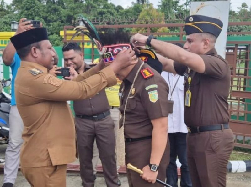 Tampak  Wakil Bupati Teluk Bintuni menyematkan mahkota dan noken adat kepada Kepala Kejaksaan Negeri Teluk Bintuni yang baru, sebagai simbol kehormatan dan penyambutan di Tanah Sisar Matiti.
(Foto: Humas Kejari Teluk Bintuni)